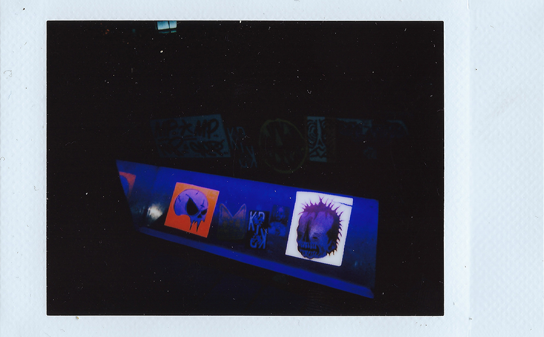 Stickers on a light under a street bench.