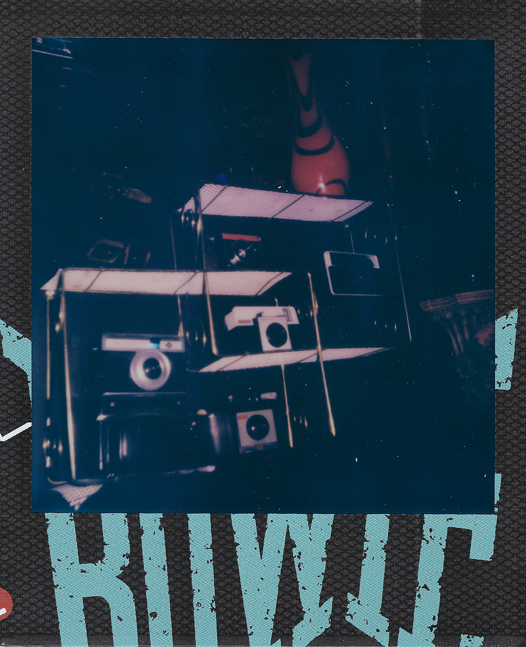 Old cameras on shelves in the dark.